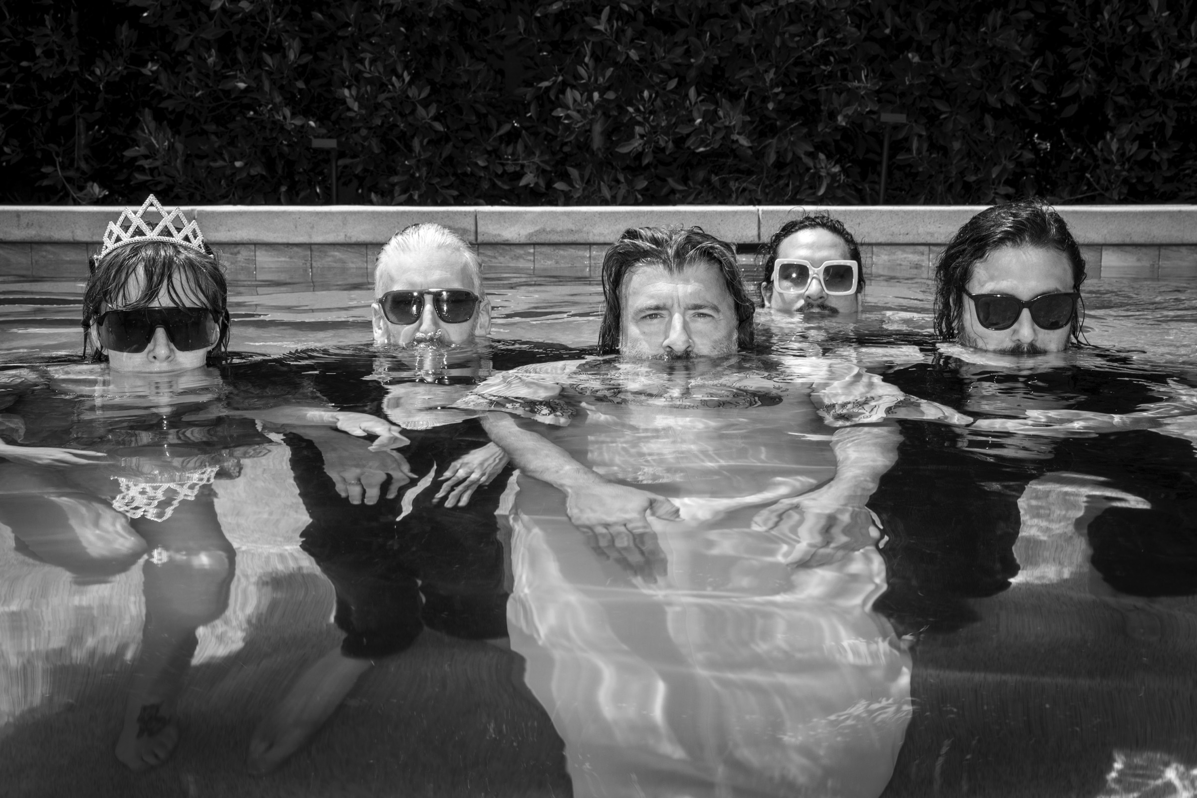 The Vincenzos floating side by side in a swimming pool, black and white.
